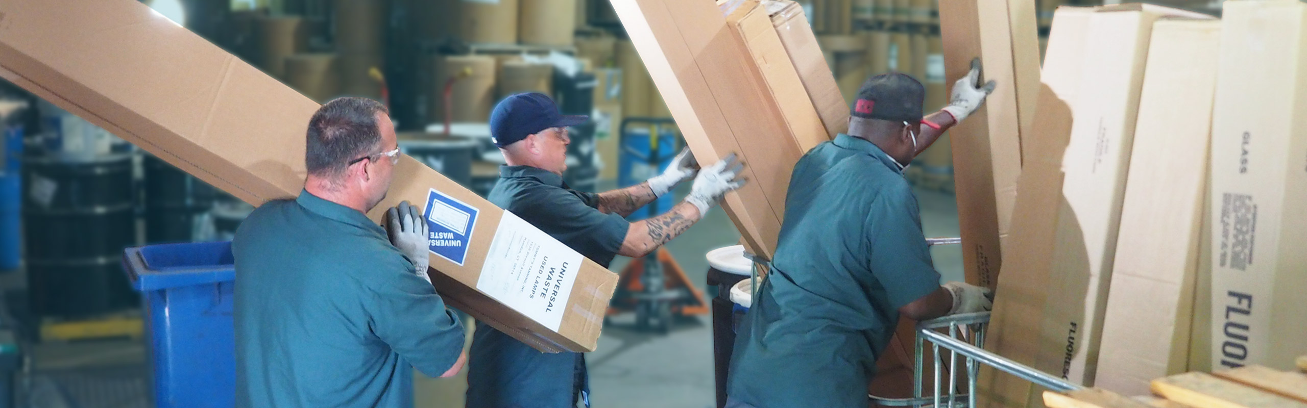 A picture of three NLR workers unloading boxes of spent fluorescent lamps in our UWH warehouse. NLR recycles fluorescent lamps and other universal waste.