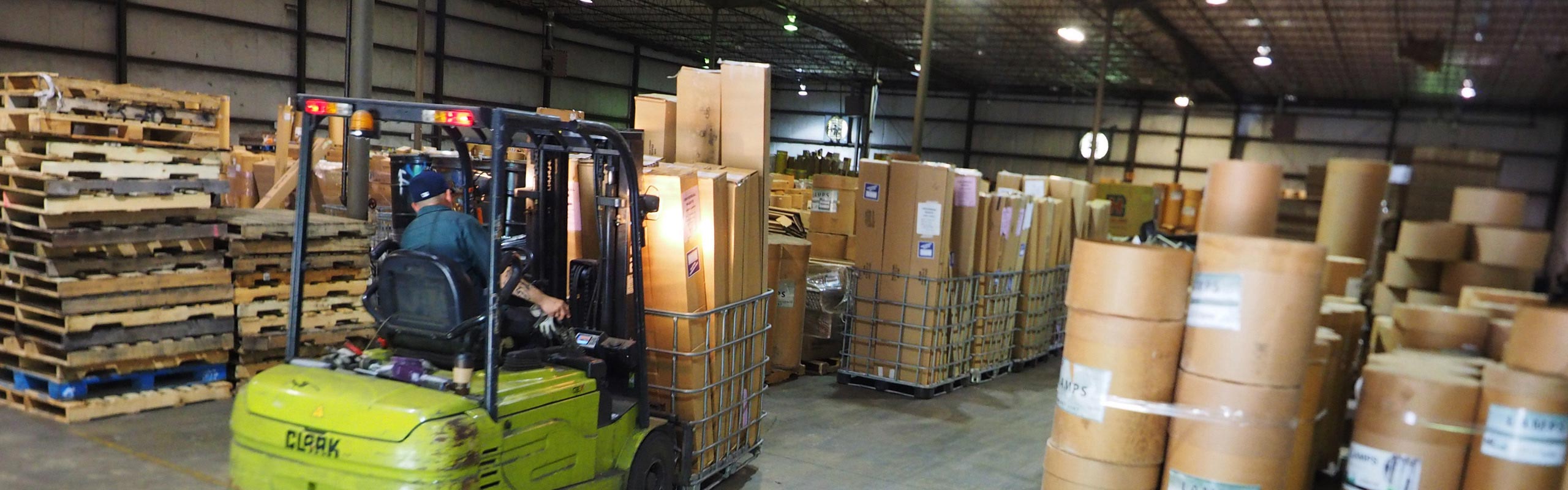A picture of forklift moving a cage full of fluorescent lamps in the warehouse. NLR recycles fluorescent lamps.